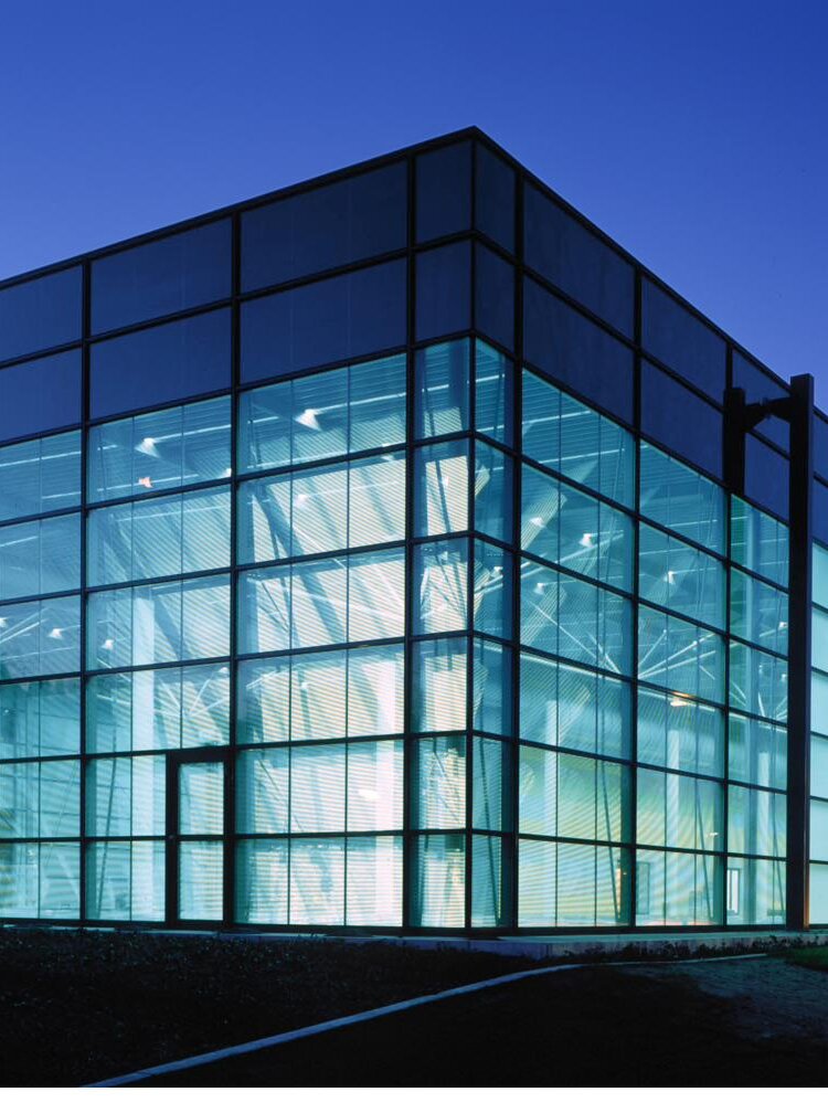 OKASOLAR sun protection glazing on the dusk-lit facade of the Schrodt office building in Iserlohn