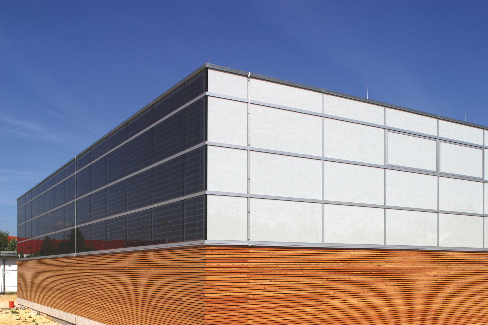 Peter Ferstl, Stadt Regensburg, OKACELL integrated into upper facade band over wood base, photovoltaic surface as architectural cladding